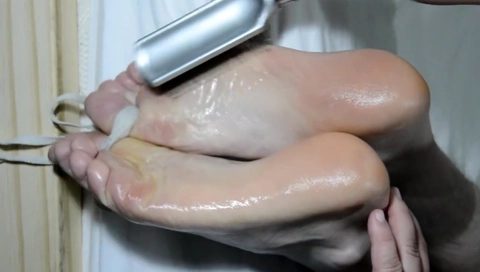 Tickling his feet.